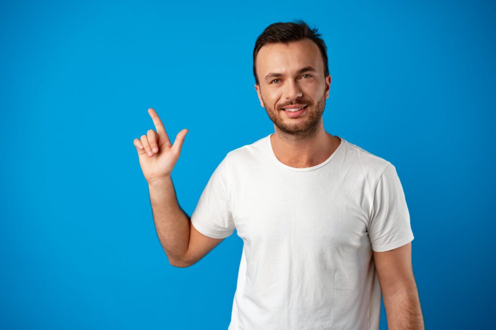 Male customer presenting new product, pointing finger at copy space